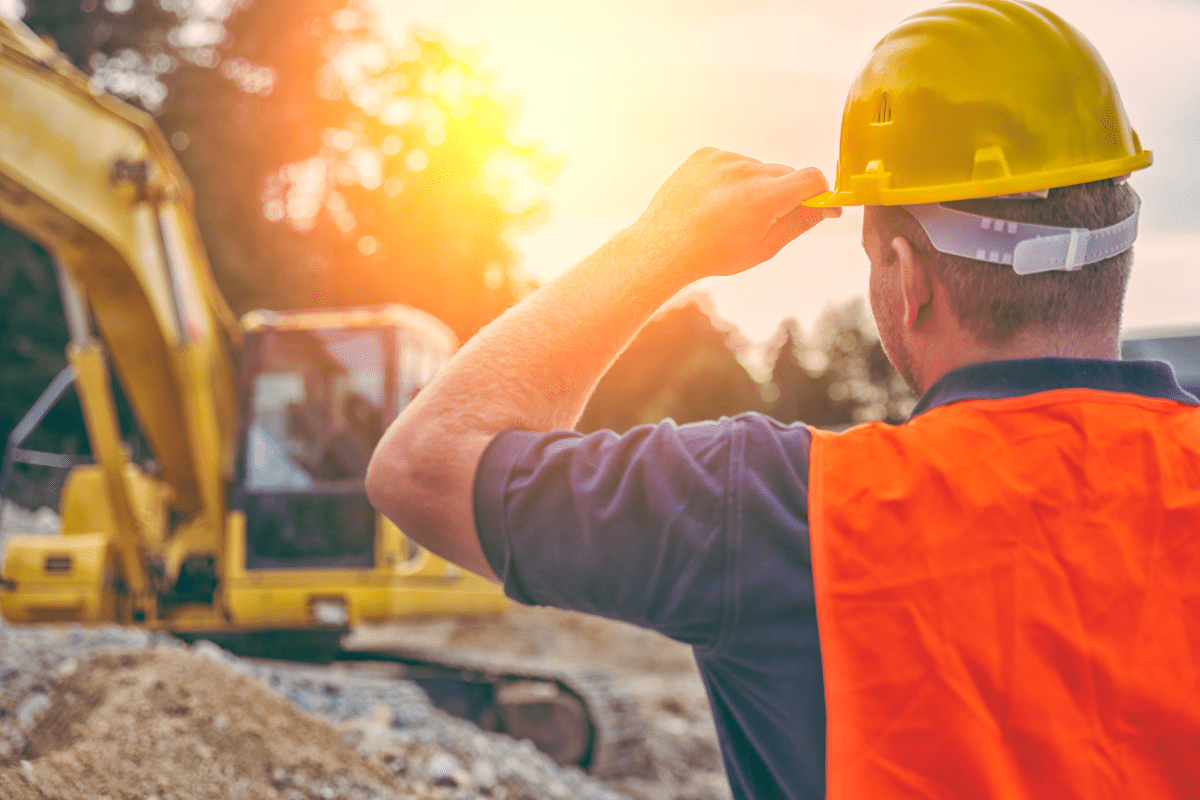 Ouvrier de chantier portant un casque sous le soleil d’été pour éviter le coup de chaud